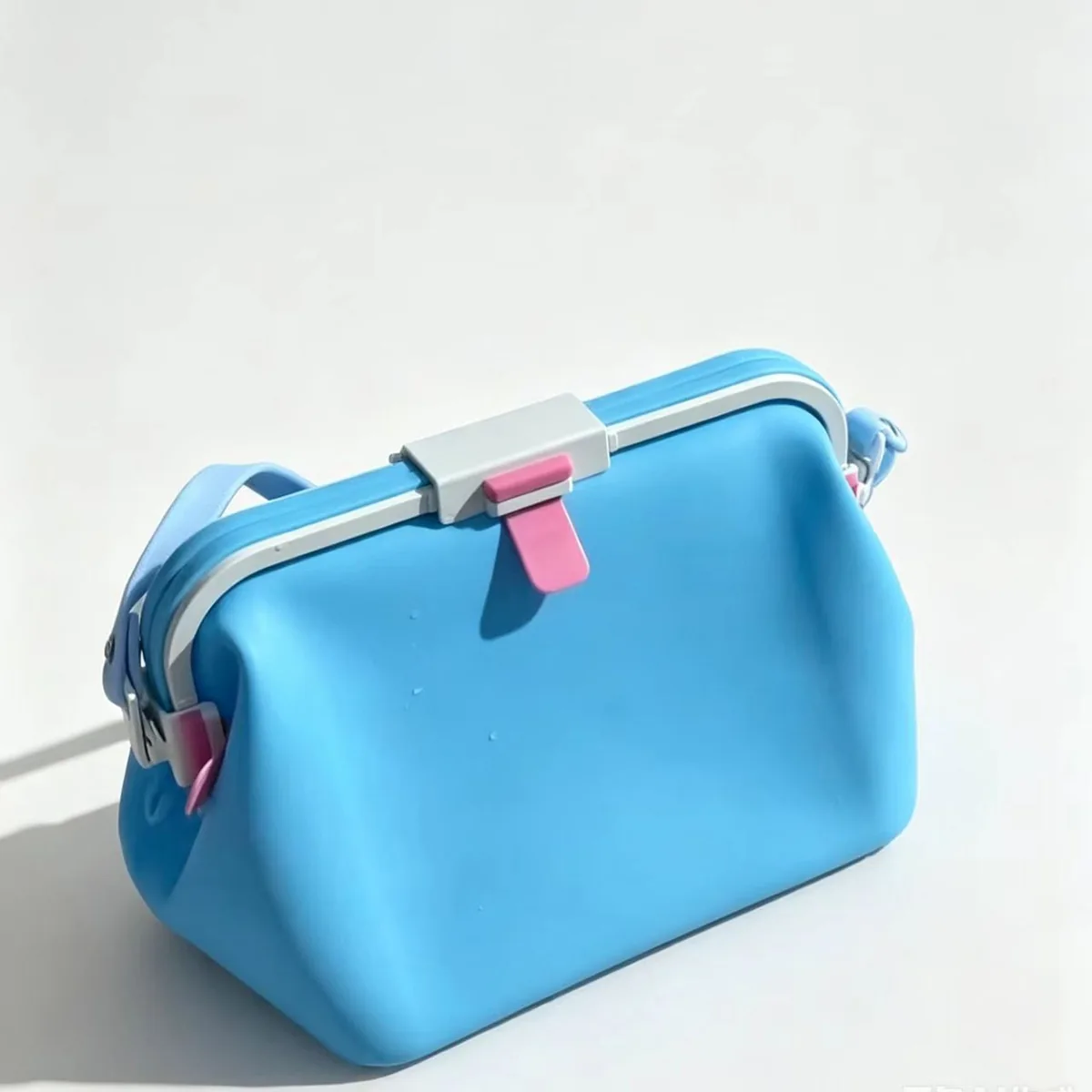 Blue silicone shoulder bag with a pale frame and pink clasp