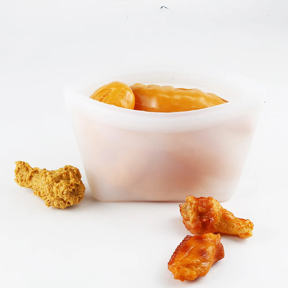 Open white silicone food pouch beside prepared food